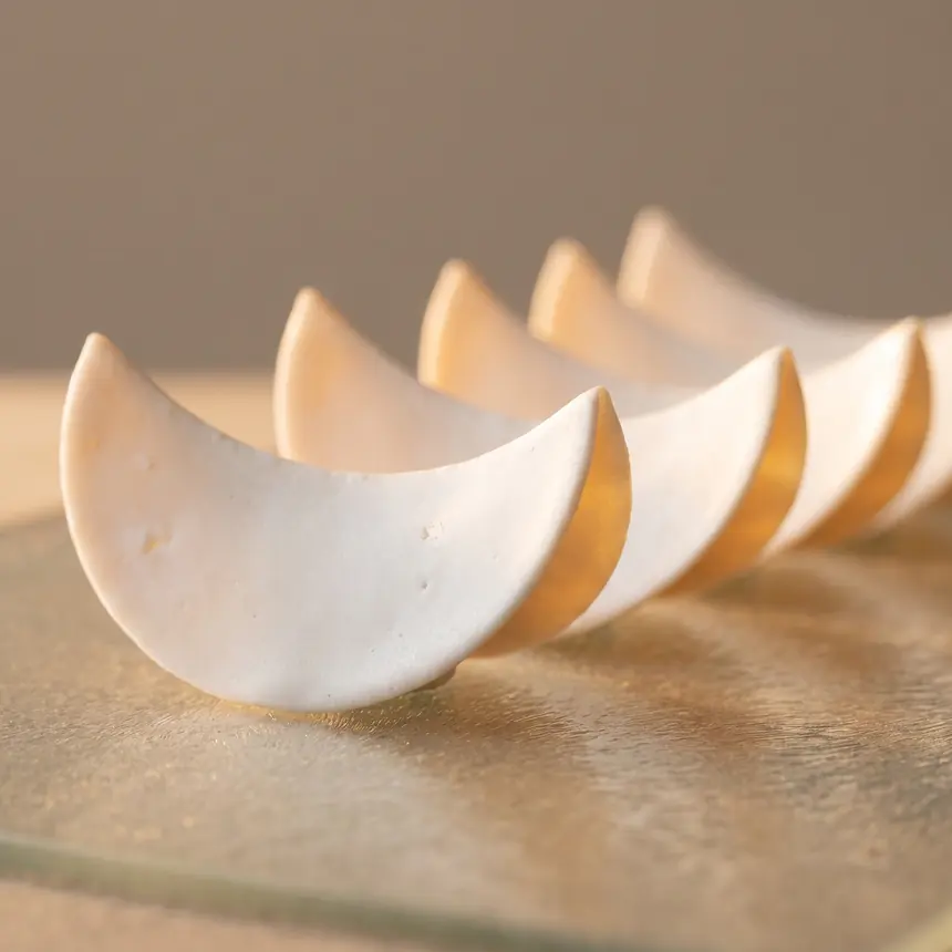 Paper-thin translucent porcelain veneer shells backlit on a glass slab